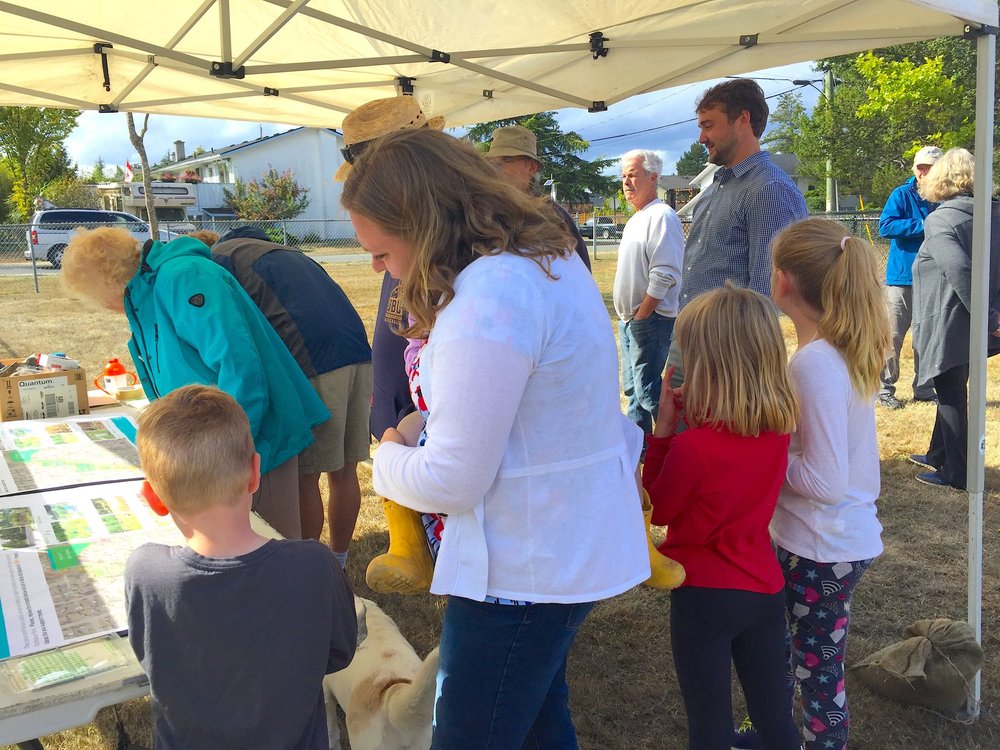 Families reviewing park concepts at an outdoor engagement event